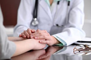 Врач держит пациента за руки